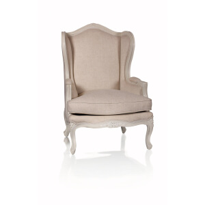 Sillón Ailette de respaldo alto con orejas, tapicería clara y estructura tallada en blanco roto.